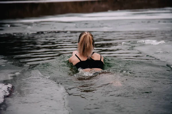 Giovane ragazza snella si bagna in inverno in un buco del fiume — Foto Stock