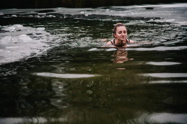 젊고 날씬 한 소녀는 강의 구멍에서 겨울에 목욕을 한다 — 스톡 사진