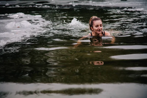 Młoda szczupła dziewczyna kąpie się zimą w dołku rzeki — Zdjęcie stockowe