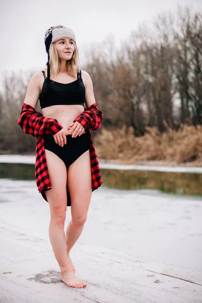 Une fille en maillot de bain et un chapeau avec un verre à la main pose en hiver dans le froid — Photo