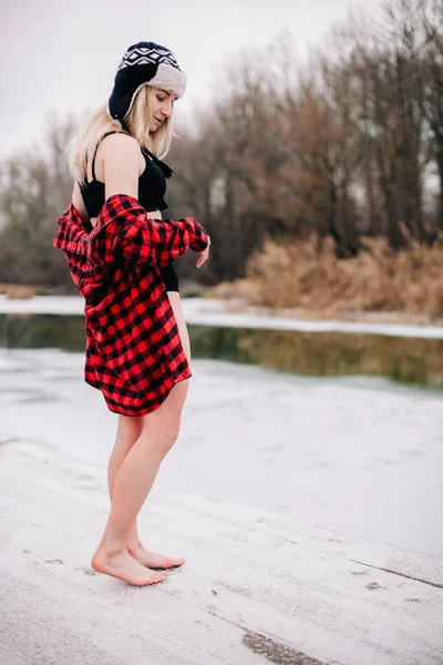 A girl in a swimsuit and a hat with a glass in her hand poses in winter in the cold — Stock Photo, Image