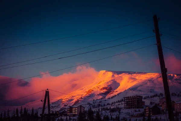 A nap első sugarai hajnalban megérintik a hegyek hófödte csúcsait. — Stock Fotó