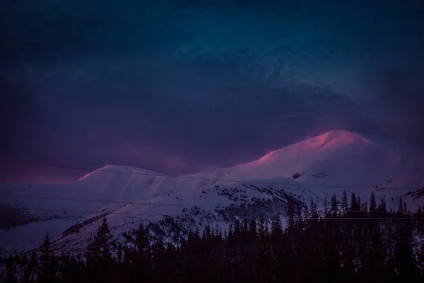 새벽의 첫 햇살이 눈덮인 산봉우리에 닿는다 — 스톡 사진