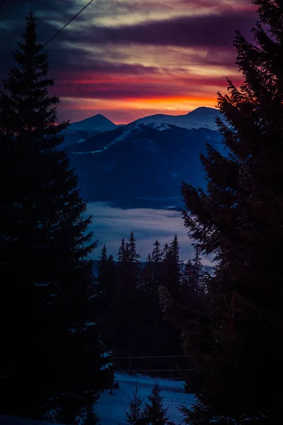 Schöne Morgendämmerung in den schneebedeckten Bergen des Winters und erstaunlich schöne Wolken — Stockfoto