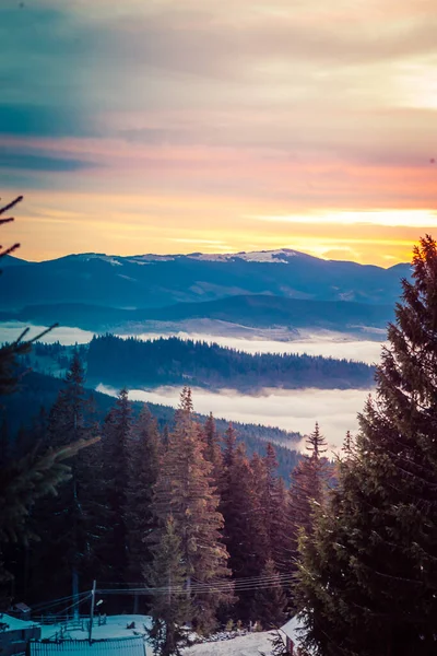 Hermoso amanecer en las montañas cubiertas de nieve de invierno y nubes increíblemente hermosas —  Fotos de Stock