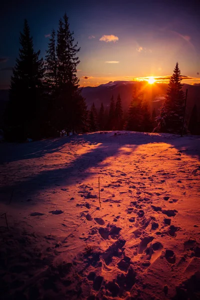 从山后升起的第一缕阳光照亮了雪坡 — 图库照片