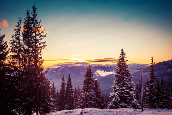 Schöne Morgendämmerung in den schneebedeckten Bergen des Winters und erstaunlich schöne Wolken — Stockfoto