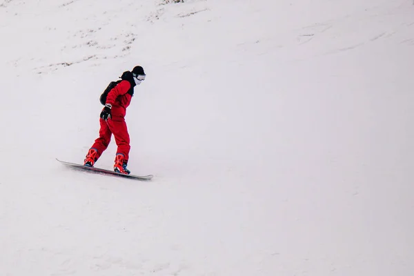 Killen i röd overall åker freeride på en snowboard — Stockfoto