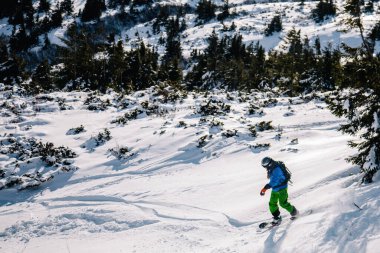 Parlak takım elbiseli adam snowboard 'a biniyor.