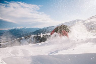 Parlak kırmızı tulumlu adam snowboard 'a bedava biniyor.