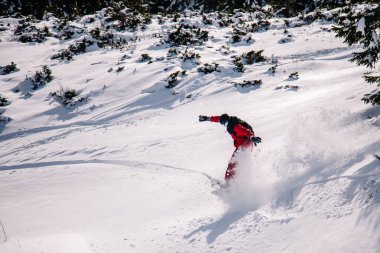 Parlak kırmızı tulumlu adam snowboard 'a bedava biniyor.