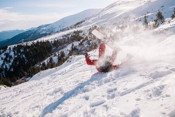 Parlak kırmızı tulumlu adam snowboard 'a düştü.
