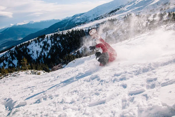 Cara de macacão vermelho brilhante cai no snowboard — Fotografia de Stock