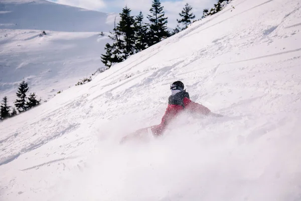 Cara de macacão vermelho brilhante cai no snowboard — Fotografia de Stock