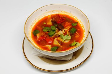 Beyaz arka planda, derin tabakta baharatlı çorba.