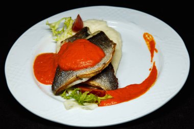 Portakal soslu beyaz tabakta Dorado balığı.
