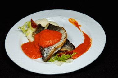 Portakal soslu beyaz tabakta Dorado balığı.