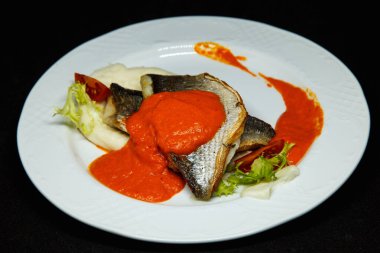 Portakal soslu beyaz tabakta Dorado balığı.