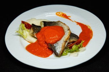 Portakal soslu beyaz tabakta Dorado balığı.