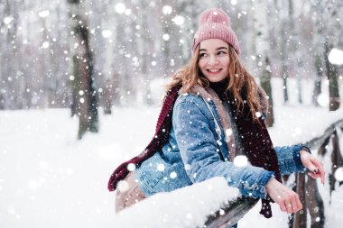 Kar yağışı sırasında parkta genç bir kızın portresi