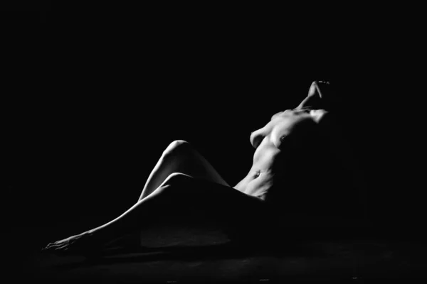 Bir fotoğraf stüdyosundaki siyah arka planda genç, ince bir siluet.