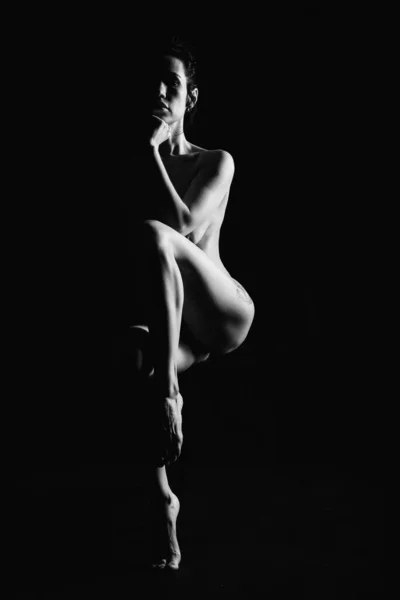 Silhouette of a young, slender, on a black background in a photo studio — ストック写真