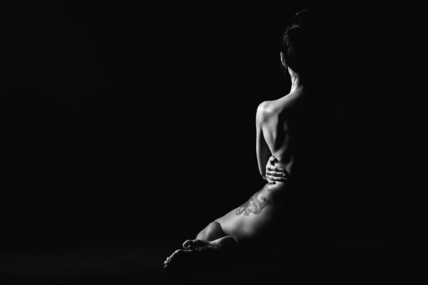 Silhuett av en ung, smal, på en svart bakgrund i en fotostudio — Stockfoto