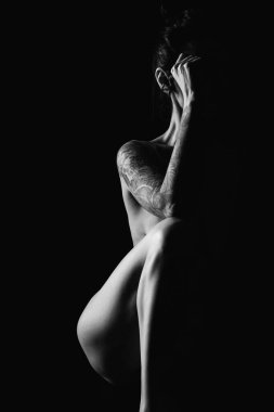 Bir fotoğraf stüdyosundaki siyah arka planda genç, ince bir siluet.