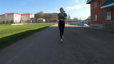 Genç, narin kız stadyumda antrenman yapıyor.