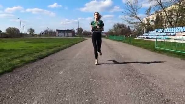 Young, slender girl runs training in the stadium — ストック動画