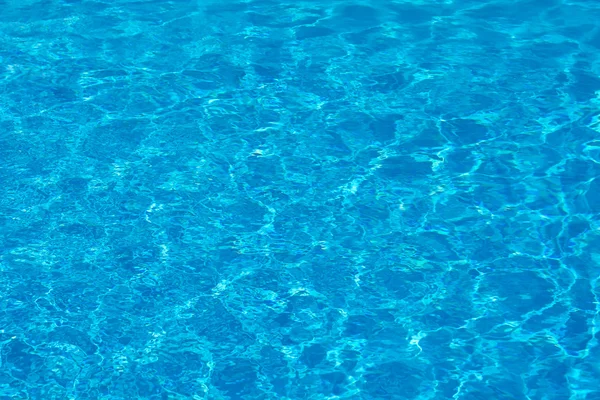 Eau de piscine bleue avec reflets solaires. — Photo