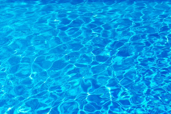 Blauw zwembadwater met zonreflecties. — Stockfoto