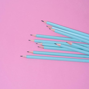 Pembe arka planda kalemler, ofis malzemeleri, sanatçılar için ekipmanlar.