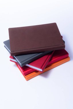 Kırtasiye, beyaz arkaplan üzerine not defterleri, parlak günlükler, okul ve ofis için renkli