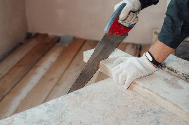 Bir marangoz testereyle ev yapmak için tahta testeresi kullanır. Yakın çekim, ahşap testeresi, ev inşaatı, tahta döşeme, yapı malzemesi