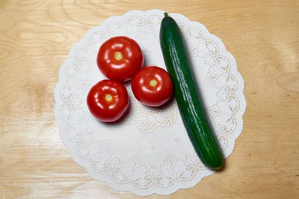 Tahta arka planda taze domates ve salatalık. Salata malzemeleri, sağlıklı yiyecekler, vejetaryen yemekleri.