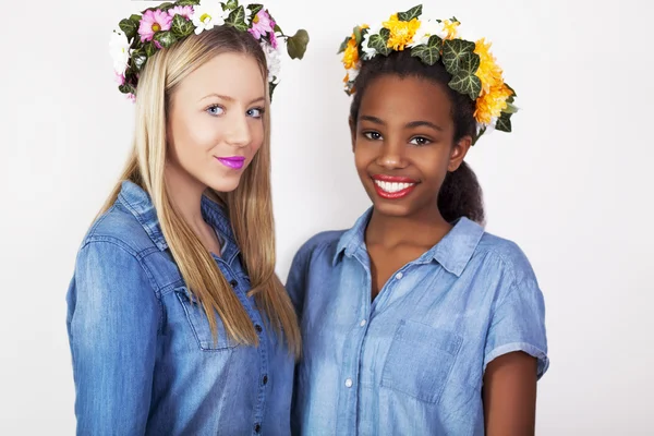 Schattige tiener gemengd ras meisjes dragen krans van bloemen, studio shoot. — Stockfoto