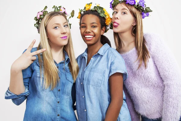 Cute teenage mixed race girls wearing wreath of flowers, studio shoot. — Stock Photo, Image