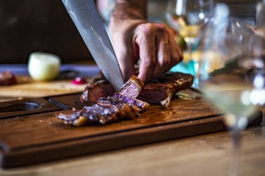 Fresh beautiful beef steak, close up. Hot roasted steak, on a wooden cutting board and glass of wine. Food concept. 
