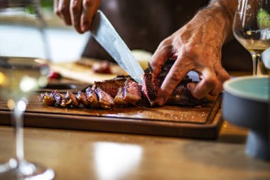 Fresh beautiful beef steak, close up. Hot roasted steak, on a wooden cutting board and glass of wine. Food concept. 