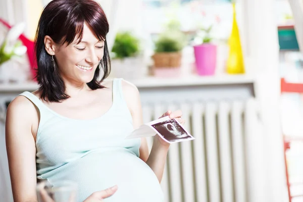 Pregnant woman holding ultrasound — Stock Photo, Image