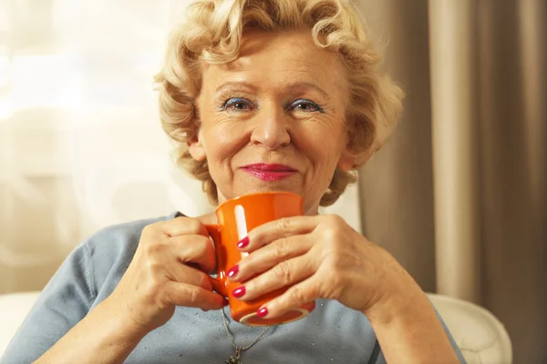 Die blonde Seniorin ruht sich zu Hause aus. Nahaufnahme. — Stockfoto