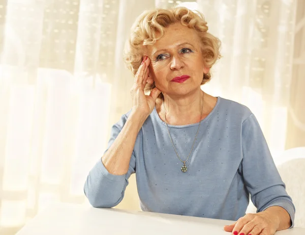 Blonde senior woman has a headache. — Stock Photo, Image