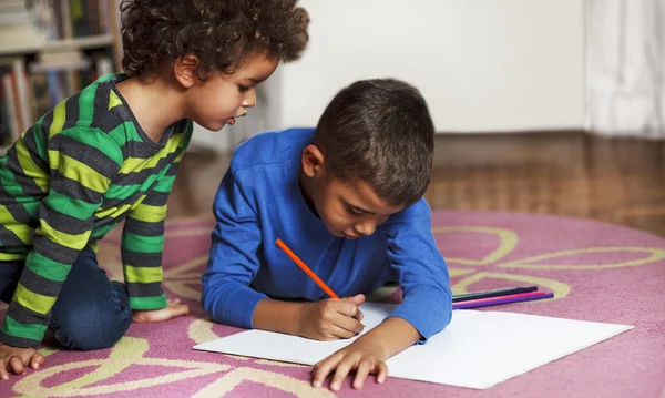 Young blandad ras pojkar ritning på papper med krita. — Stockfoto