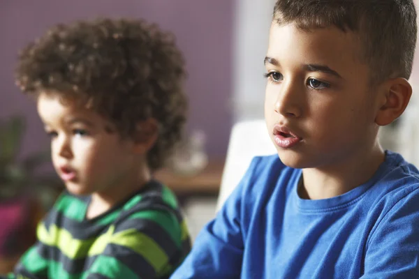 Due fratelli seduti a guardare cartoni animati in televisione — Foto Stock