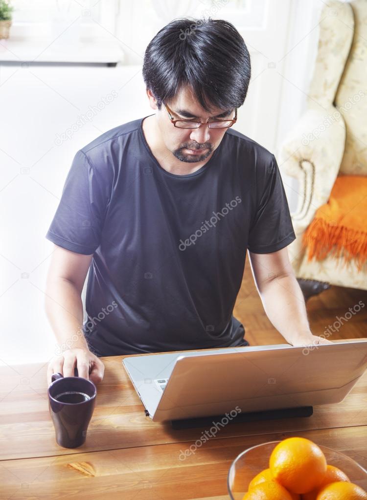 Man working on laptop, at home