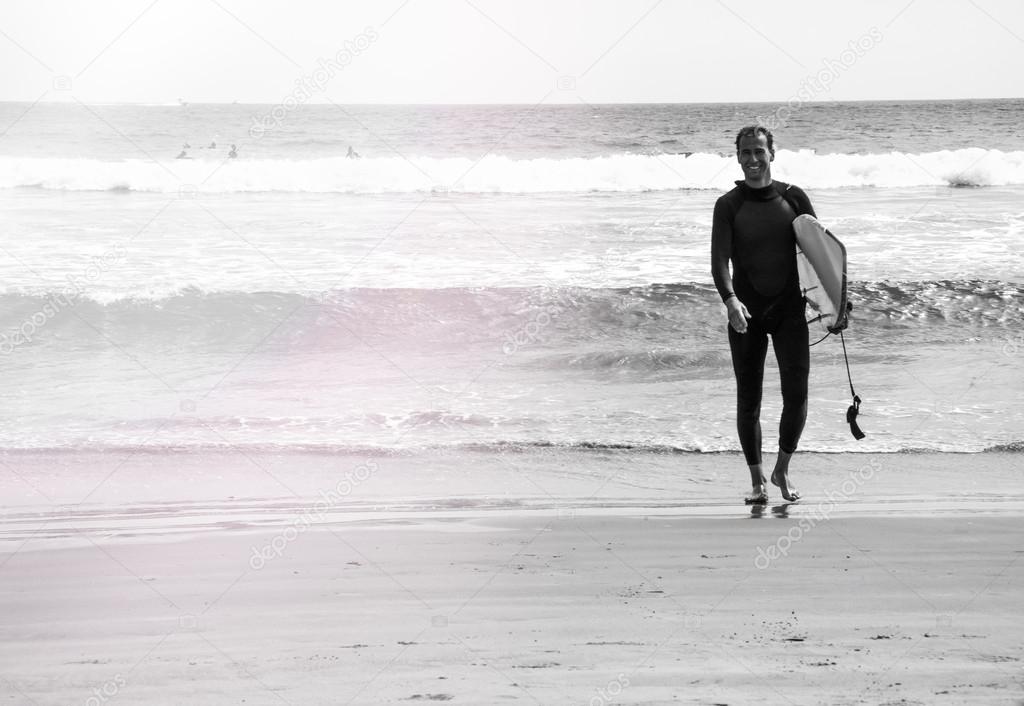 Young surfer on the beach, black and white