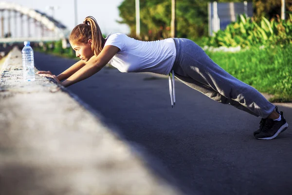 Ragazza sportiva facendo flessioni — Foto Stock