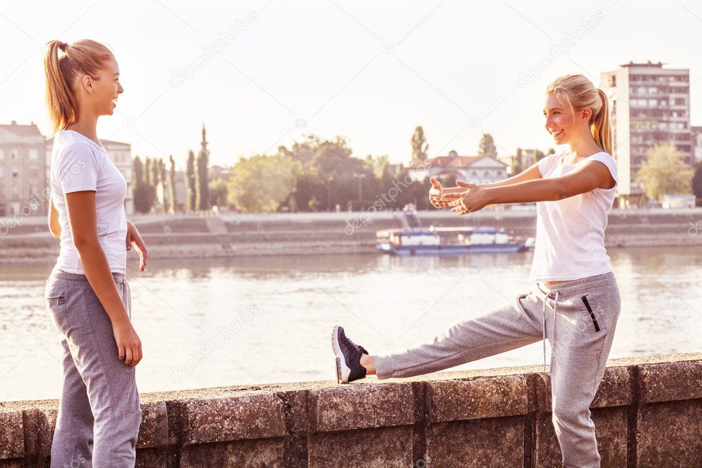 Exercise, two cute girls stretching outdoor