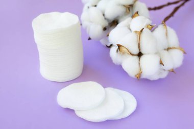 Pamuk çiçeklerle dolu mor sırt çantalarında bir sürü beyaz pamuk yastık. Yüz temizleme güzellik tedavisi kavramı.